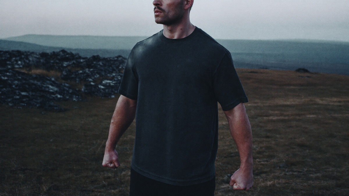 A powerfully built figure on a cold windswept highland at dawn